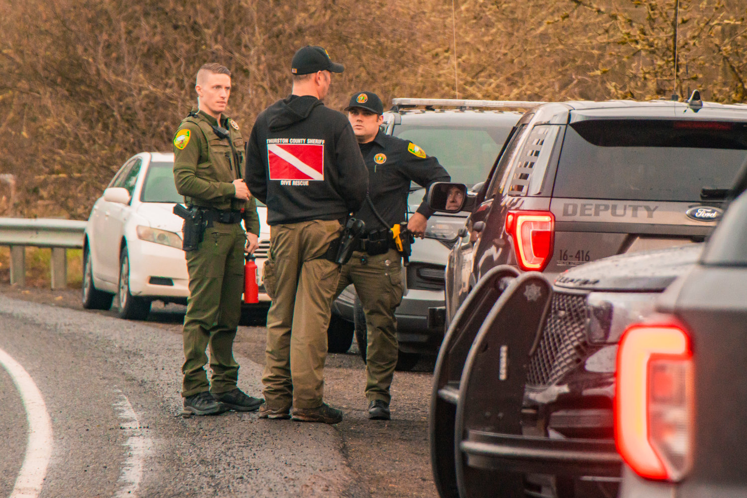 A member of the Thurston County Sheriff's Office Dive and Rescue crew speaks to deputies along Highway 603 near the Chehalis River in Adna.